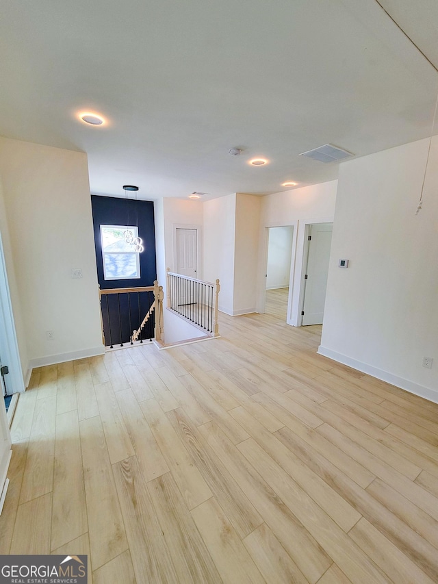 spare room featuring baseboards and light wood finished floors