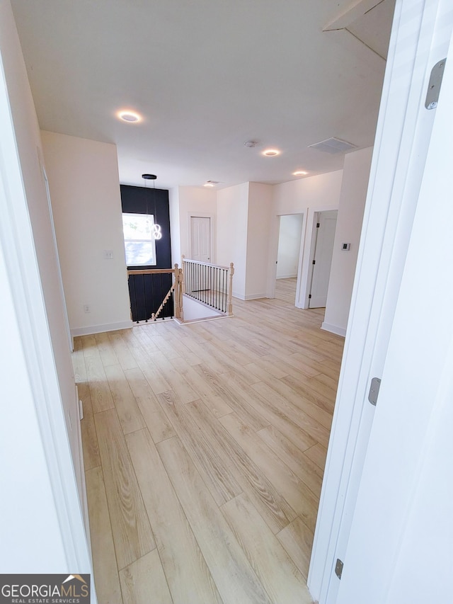 interior space featuring baseboards, light wood-style floors, and attic access