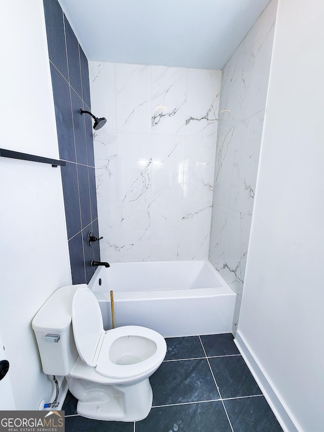 bathroom with tile patterned floors, toilet, washtub / shower combination, and baseboards