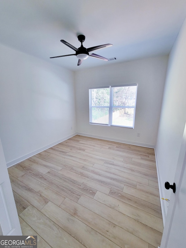 empty room featuring visible vents, baseboards, light wood-type flooring, and ceiling fan