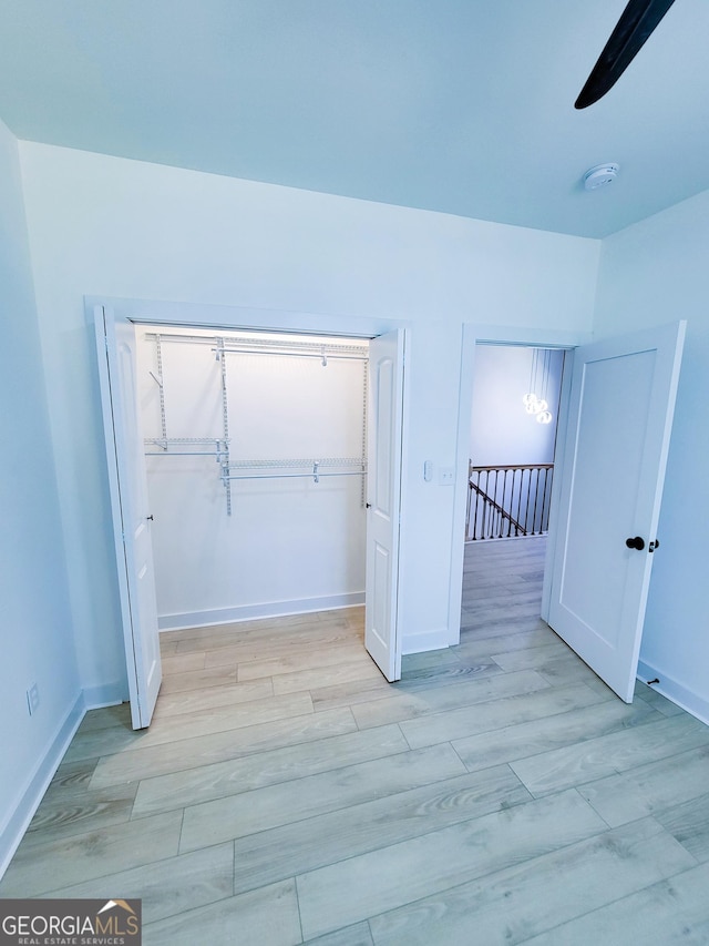 unfurnished bedroom with a closet, light wood-type flooring, and baseboards