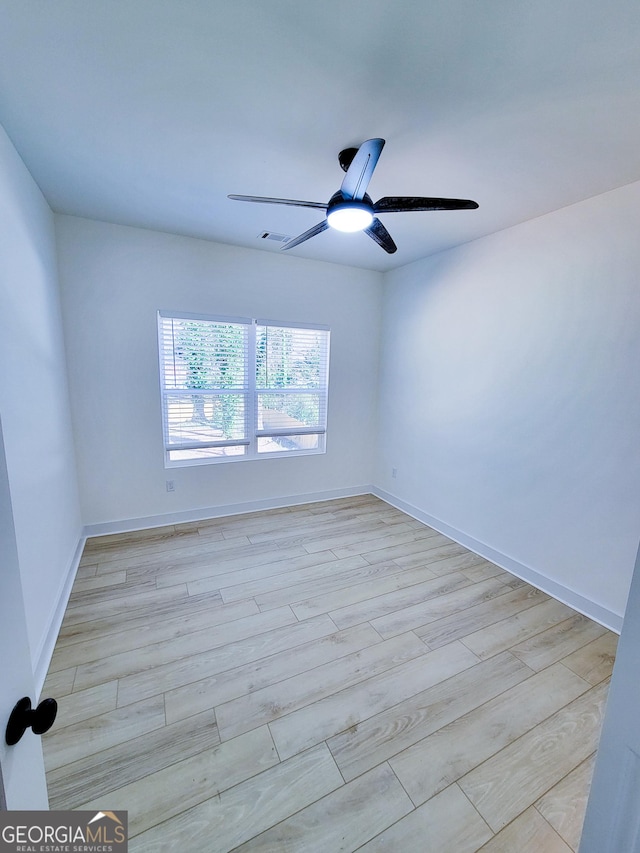 spare room with baseboards, visible vents, light wood finished floors, and ceiling fan