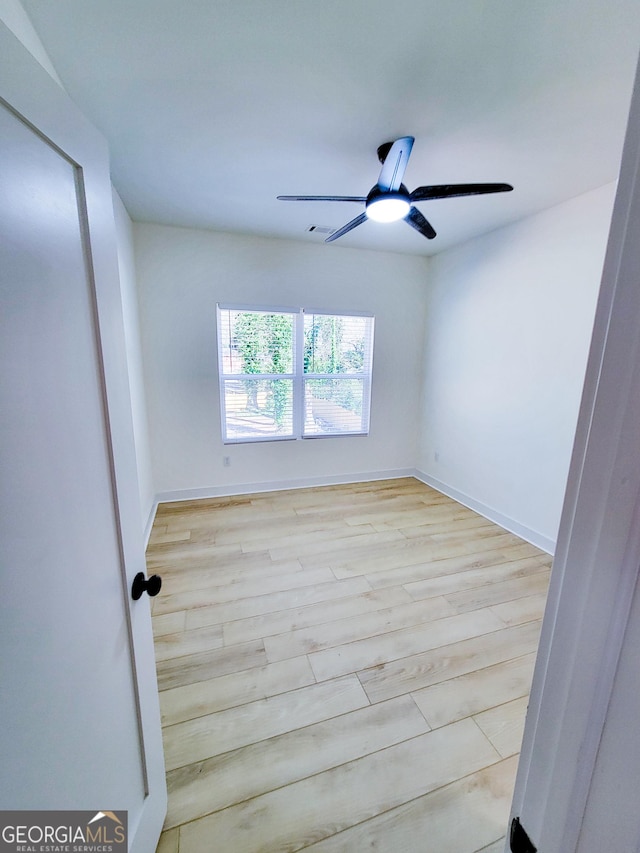 spare room featuring baseboards, a ceiling fan, and wood finished floors