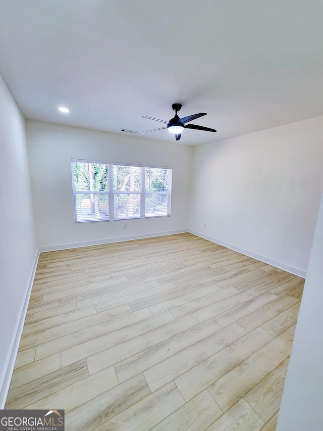 empty room with light wood finished floors, visible vents, baseboards, and a ceiling fan