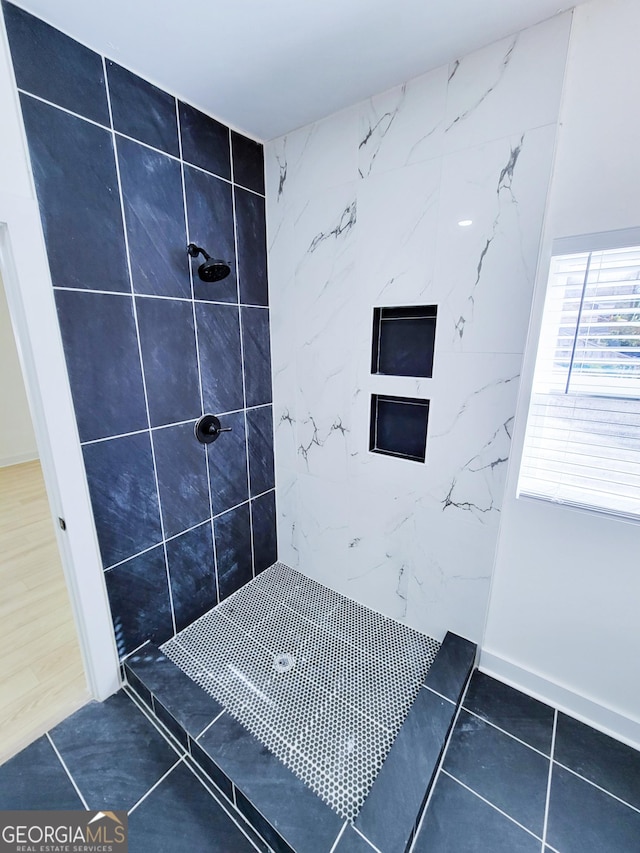 full bathroom featuring tile patterned flooring and tiled shower