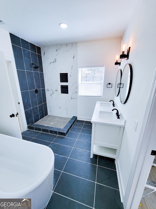 bathroom featuring tile patterned floors, baseboards, tiled shower, and double vanity