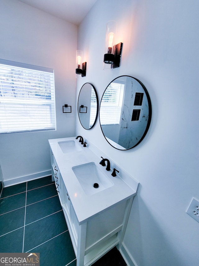 full bathroom featuring tile patterned floors, double vanity, baseboards, and a sink