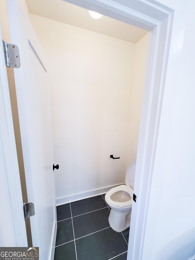 bathroom with tile patterned flooring, toilet, and baseboards