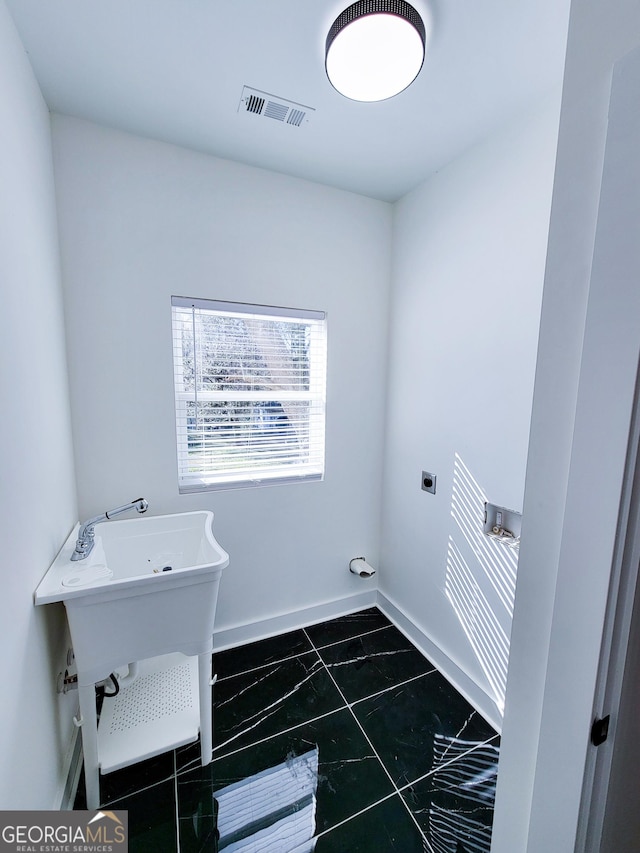 washroom with electric dryer hookup, visible vents, baseboards, and laundry area