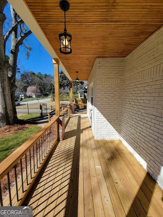 wooden terrace featuring fence