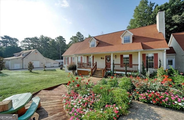 cape cod house with a detached garage, covered porch, and a front lawn