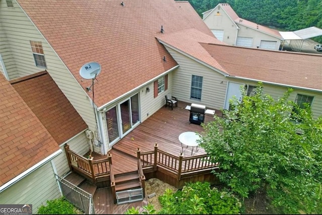 back of property with a wooden deck and a shingled roof