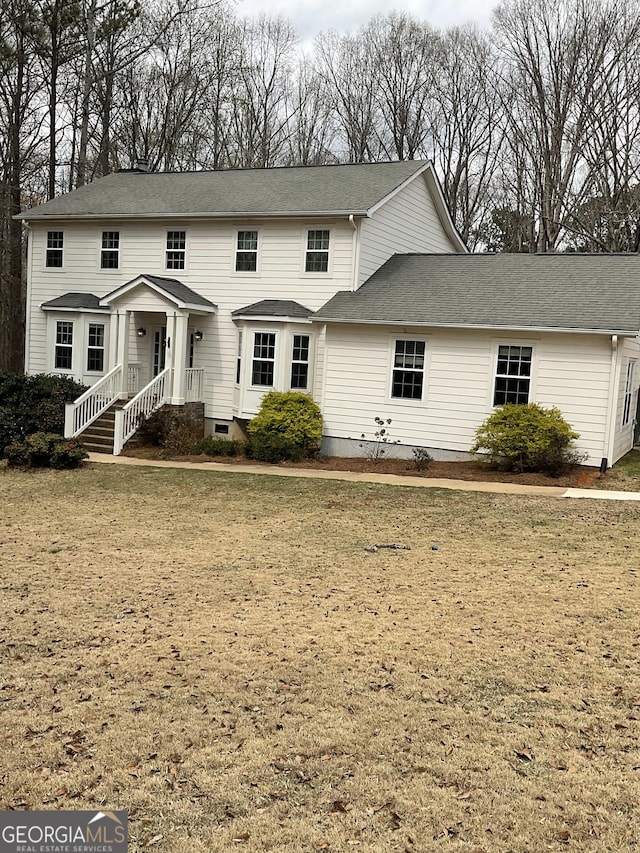 view of front of home with crawl space and roof with shingles