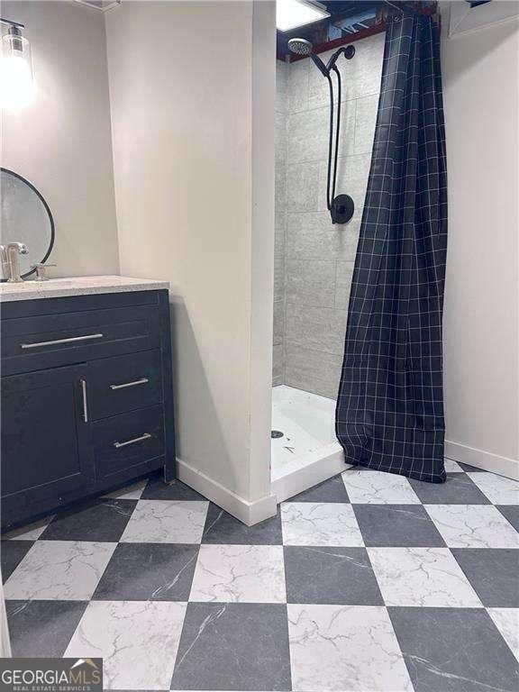 full bathroom with tile patterned floors, a shower stall, vanity, and baseboards