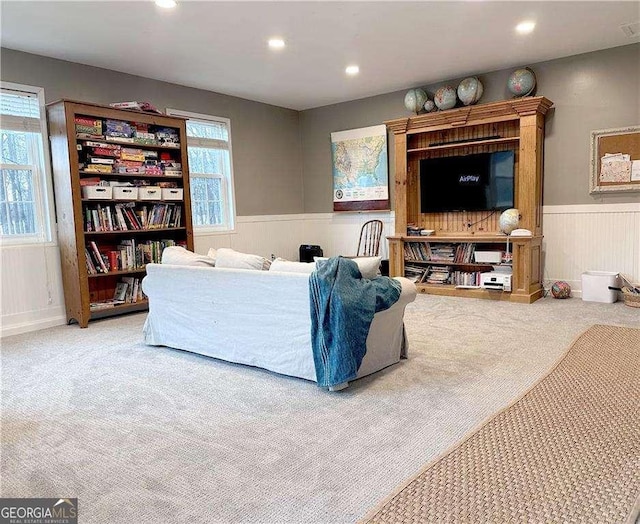 carpeted living area featuring recessed lighting and wainscoting