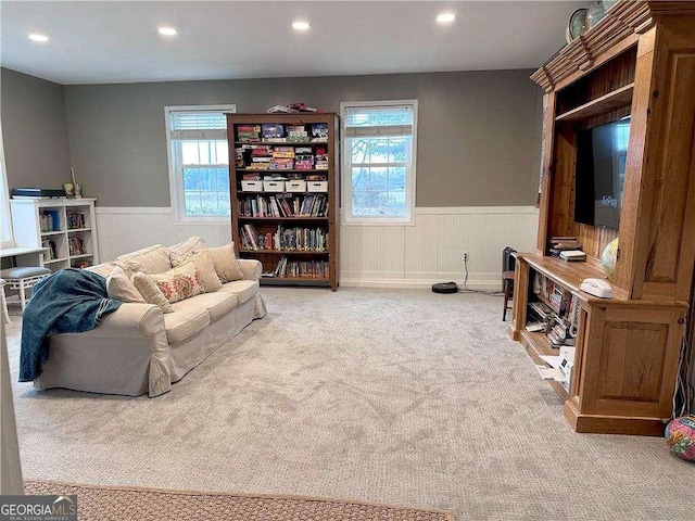 living room with a wainscoted wall, a wealth of natural light, and carpet floors