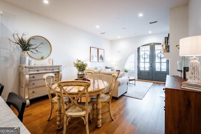 dining area featuring wood finished floors, recessed lighting, french doors, and visible vents