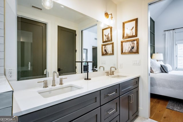 bathroom featuring a sink, visible vents, connected bathroom, and wood finished floors