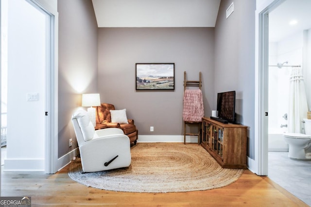 living area featuring baseboards and wood finished floors