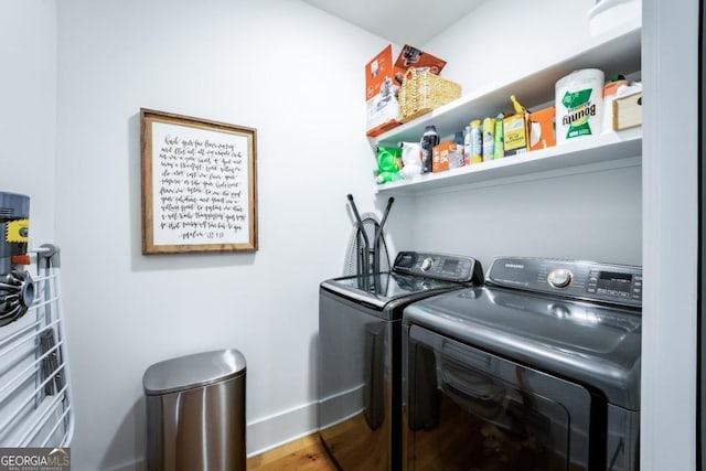 laundry area featuring washing machine and clothes dryer, laundry area, baseboards, and wood finished floors