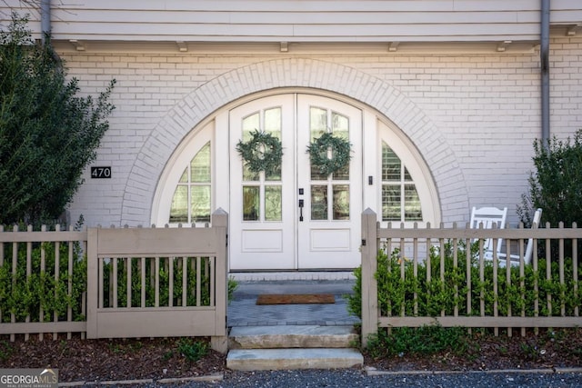 entrance to property with brick siding and fence