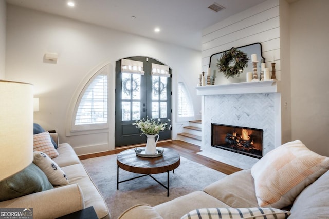 living area with plenty of natural light, french doors, visible vents, and wood finished floors