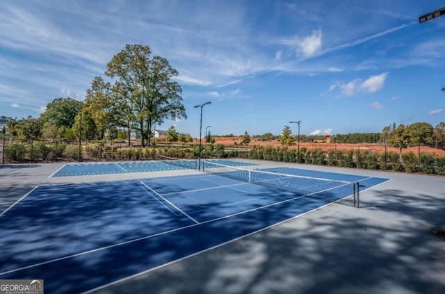 view of tennis court featuring fence