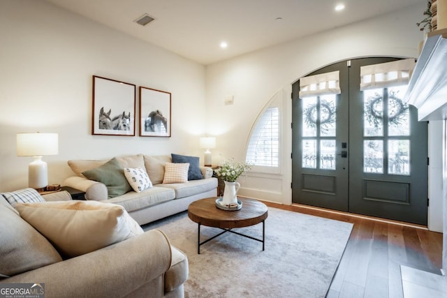 living room featuring visible vents, recessed lighting, french doors, and wood finished floors