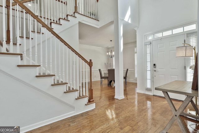 41 Eastlake Lndg, Newnan, GA 30265 - entryway featuring a towering ceiling, wood finished floors, stairs, ornamental molding, and a chandelier