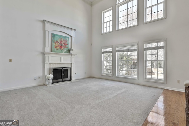 41 Eastlake Lndg, Newnan, GA 30265 - unfurnished living room featuring a fireplace, a high ceiling, and hardwood / wood-style floors
