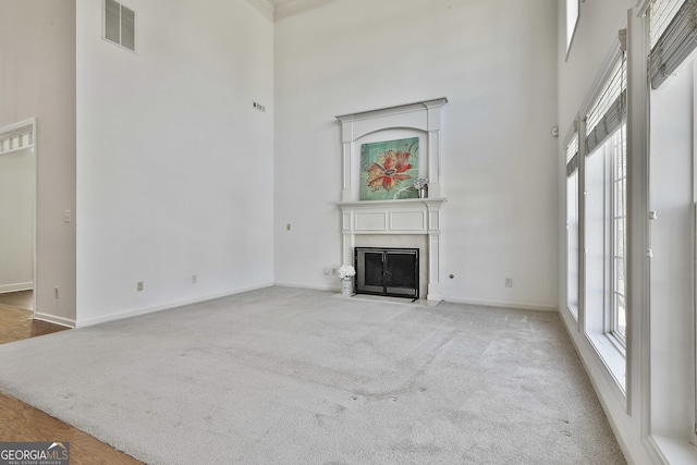 41 Eastlake Lndg, Newnan, GA 30265 - unfurnished living room featuring a high ceiling, a fireplace with flush hearth, and light carpet