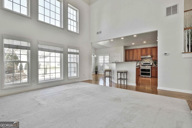 41 Eastlake Lndg, Newnan, GA 30265 - living area with a towering ceiling, plenty of natural light, carpet, and wood finished floors