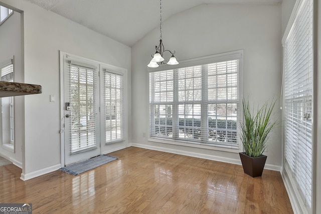 41 Eastlake Lndg, Newnan, GA 30265 - unfurnished dining area with lofted ceiling, a chandelier, and wood finished floors