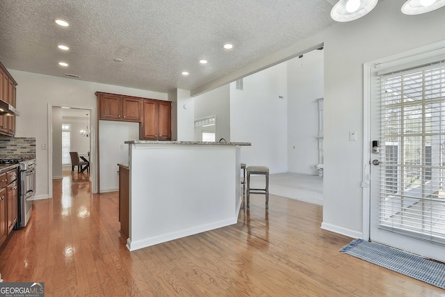 41 Eastlake Lndg, Newnan, GA 30265 - kitchen featuring range with two ovens, a textured ceiling, recessed lighting, light wood-style flooring, and brown cabinetry