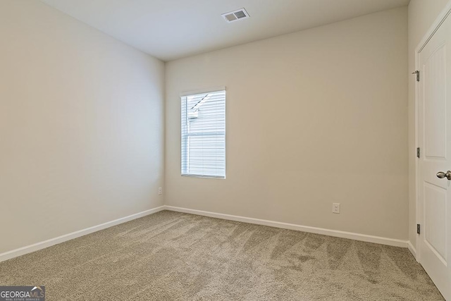 spare room featuring baseboards, visible vents, and carpet floors