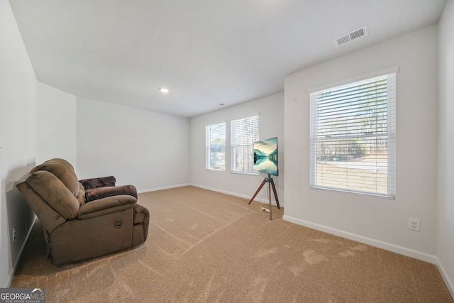 living area with visible vents, baseboards, and carpet floors