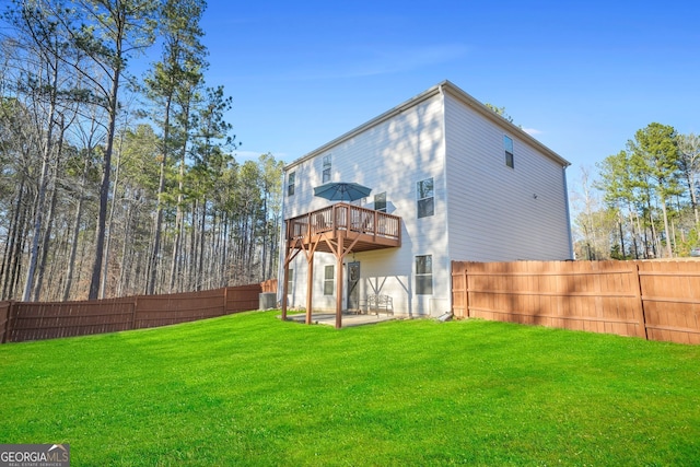 rear view of property with a patio area, a yard, a fenced backyard, and central AC