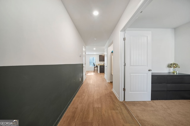 hallway featuring recessed lighting, light wood-style flooring, and baseboards