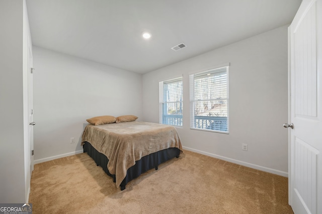 carpeted bedroom featuring baseboards and visible vents