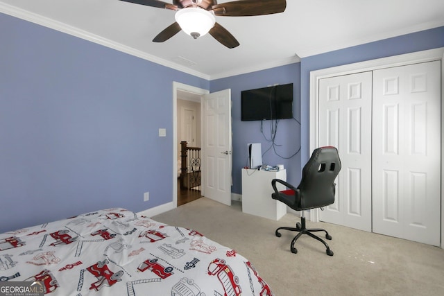 bedroom with a closet, ornamental molding, baseboards, ceiling fan, and carpet