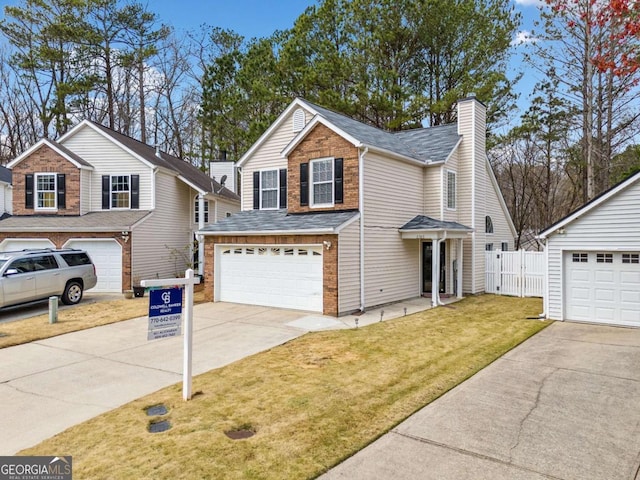 traditional home with fence, a front yard, a chimney, a garage, and driveway