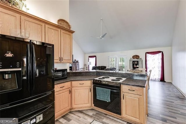 144 Bobs Dr, Mableton, GA 30126 - kitchen with dark countertops, light brown cabinetry, range with electric stovetop, a peninsula, and black fridge with ice dispenser