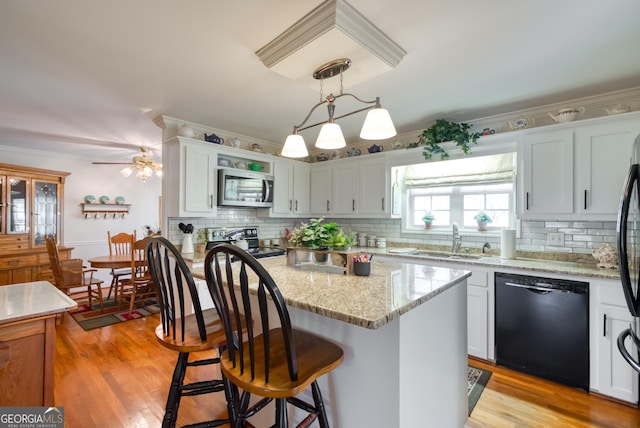 1650 Pierce Dairy Rd, Madison, GA 30650 - kitchen with black dishwasher, a sink, ornamental molding, stainless steel microwave, and electric range