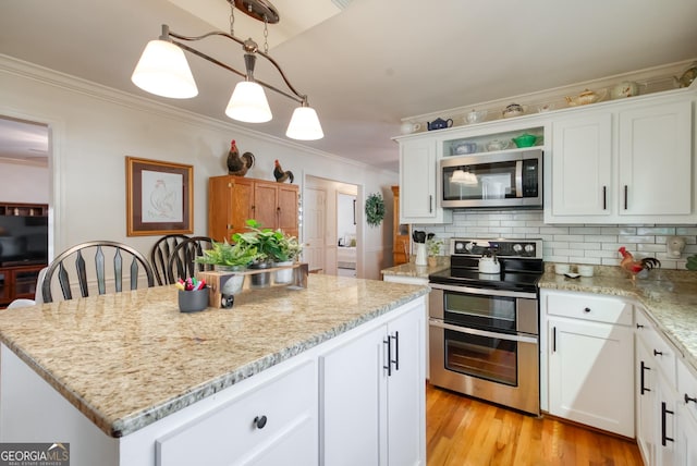 1650 Pierce Dairy Rd, Madison, GA 30650 - kitchen with light stone counters, a center island, crown molding, backsplash, and stainless steel appliances