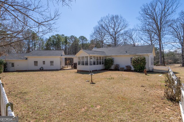1650 Pierce Dairy Rd, Madison, GA 30650 - rear view of house featuring a shingled roof, a sunroom, a yard, fence, and cooling unit