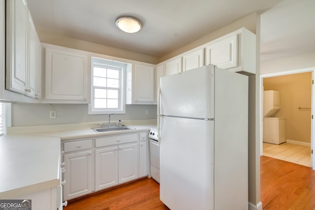 1650 Pierce Dairy Rd, Madison, GA 30650 - kitchen featuring white cabinets, a sink, freestanding refrigerator, stove, and light wood-style flooring