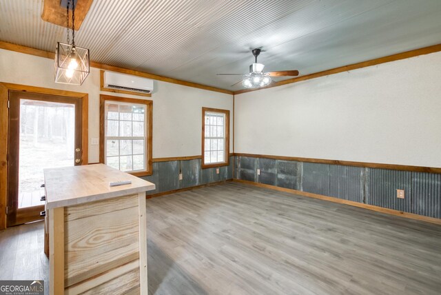 1650 Pierce Dairy Rd, Madison, GA 30650 - interior space with a ceiling fan, decorative light fixtures, wainscoting, a wall unit AC, and wood finished floors