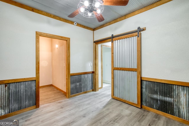1650 Pierce Dairy Rd, Madison, GA 30650 - empty room with wood finished floors, a ceiling fan, and a barn door