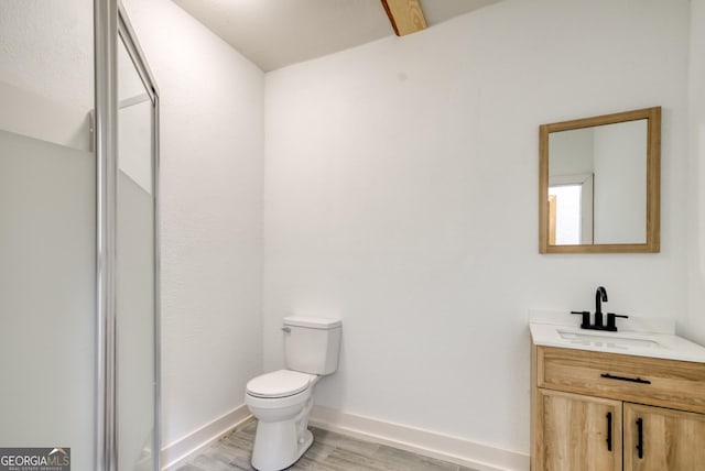 1650 Pierce Dairy Rd, Madison, GA 30650 - bathroom featuring a shower stall, vanity, toilet, wood finished floors, and baseboards