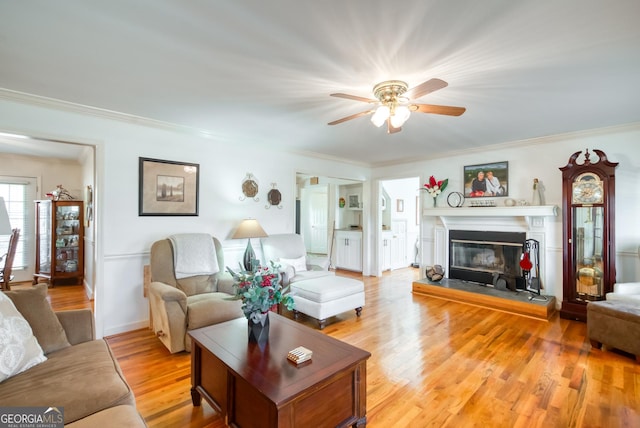 1650 Pierce Dairy Rd, Madison, GA 30650 - living area featuring ornamental molding, ceiling fan, a glass covered fireplace, and wood finished floors
